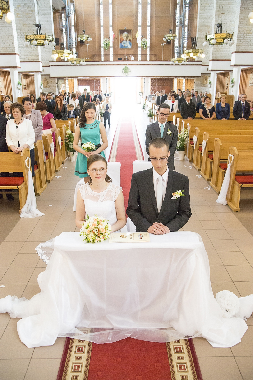 Fotograf ślubny robi artystyczne zdjęcia przed kościołem po ślubie pary młodej