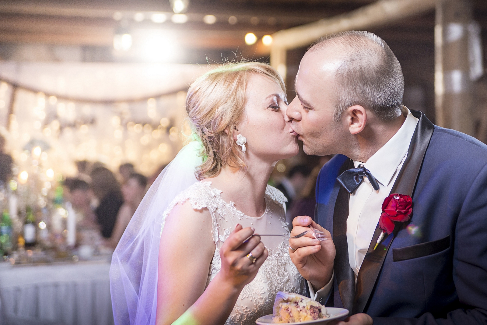 Fotograf ślubny z łodzi robi zdjęcia pary młodej krojącej tort weselny na Sali balowej